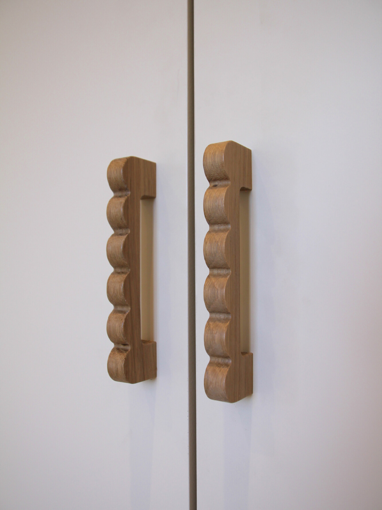 Détail des poignées en bois sculpté sur les portes de placard